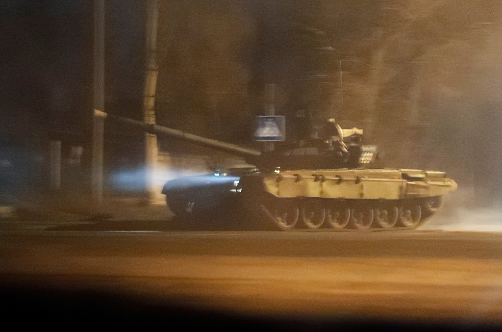 A tank drives along a street.